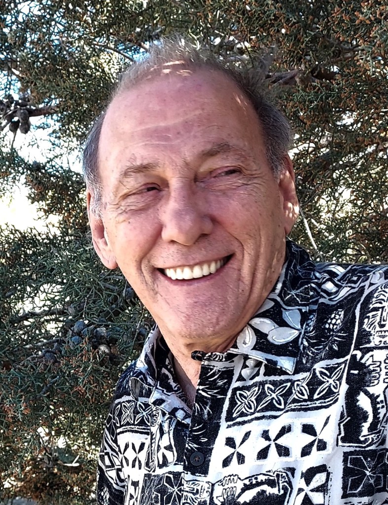 Photo of H Mikel Feilen with a Pine tree in the background.