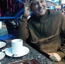 Photo of Mikel Feile sitting in a cafe having coffee.