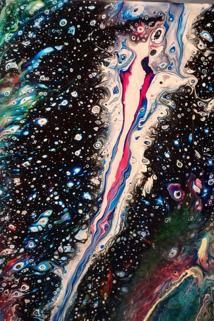 Abstract fluid art with swirling patterns of black, white, blue, pink, and green colors resembling a cosmic or underwater scene